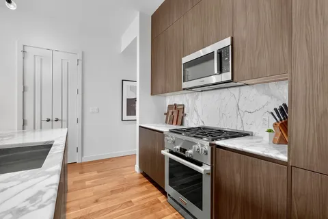 a kitchen with granite countertop cabinets stainless steel appliances and wooden floor