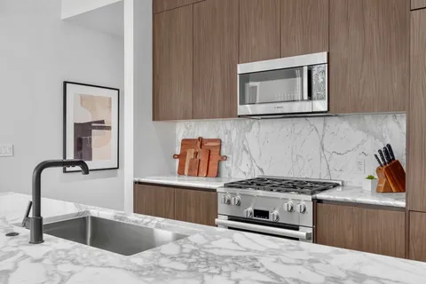 a kitchen with stainless steel appliances a stove a sink and a microwave