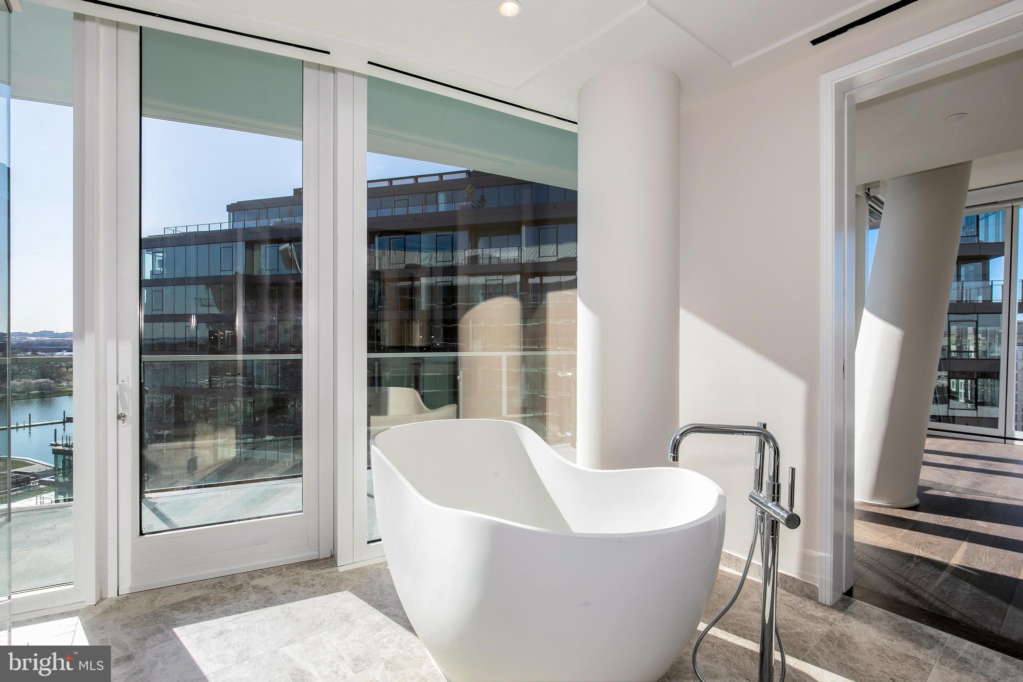 601 Wharf Street Southwest, Unit 1005 Washington, DC 20024 - Photo 12 of 19 a white bath tub sitting in a bathroom next to a window