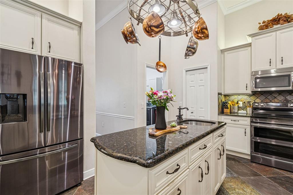 3077 Cork Road Plant City, FL 33565 - Photo 29 of 99 a kitchen with stainless steel appliances granite countertop a sink refrigerator and microwave