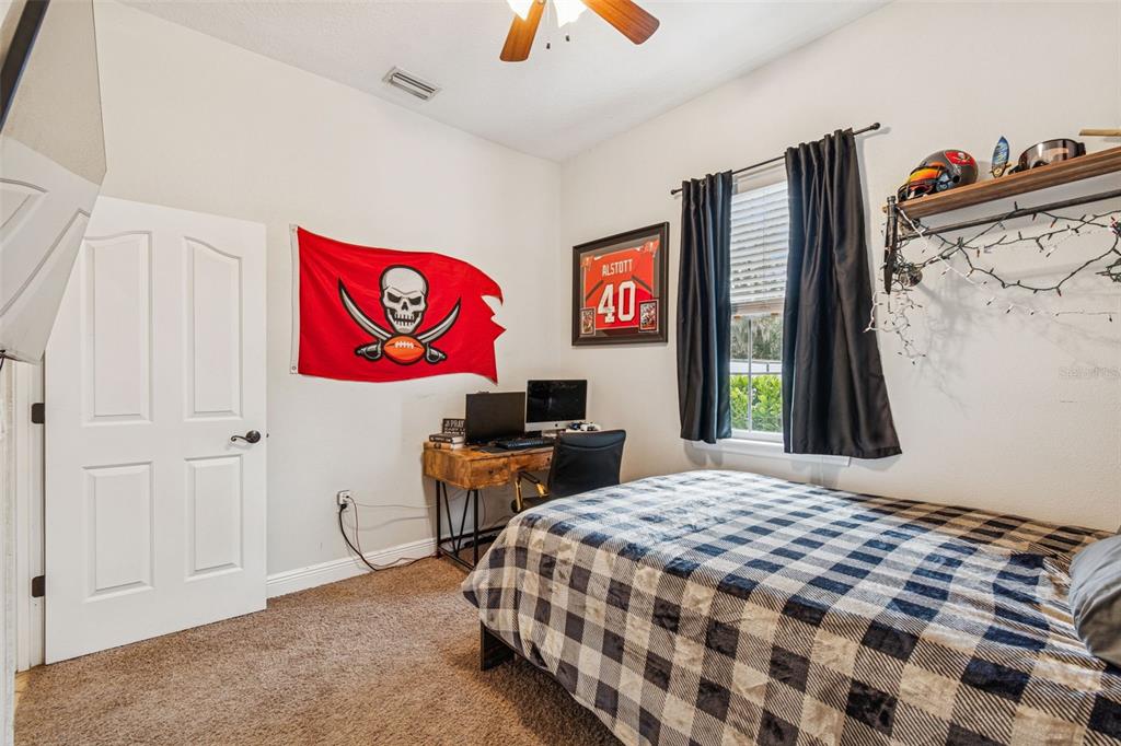 3077 Cork Road Plant City, FL 33565 - Photo 51 of 99 a bedroom with a bed and a flat tv screen on dresser