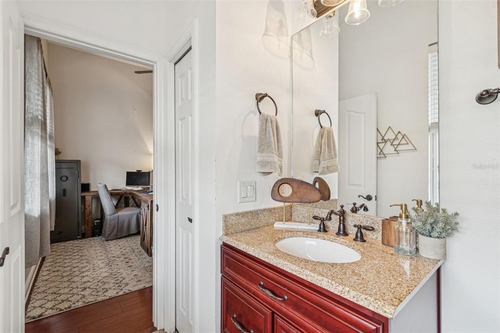 3077 Cork Road Plant City, FL 33565 - Photo 58 of 99 a en suite bathroom with a granite countertop sink and a mirror