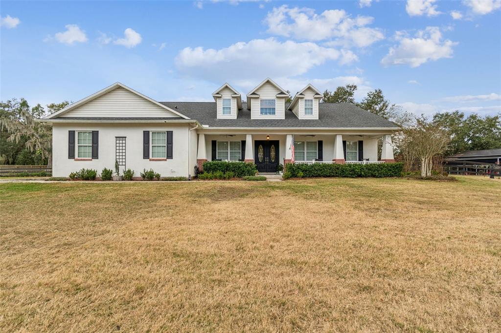 3077 Cork Road Plant City, FL 33565 - Photo 6 of 99 a front view of a house with a yard and trees