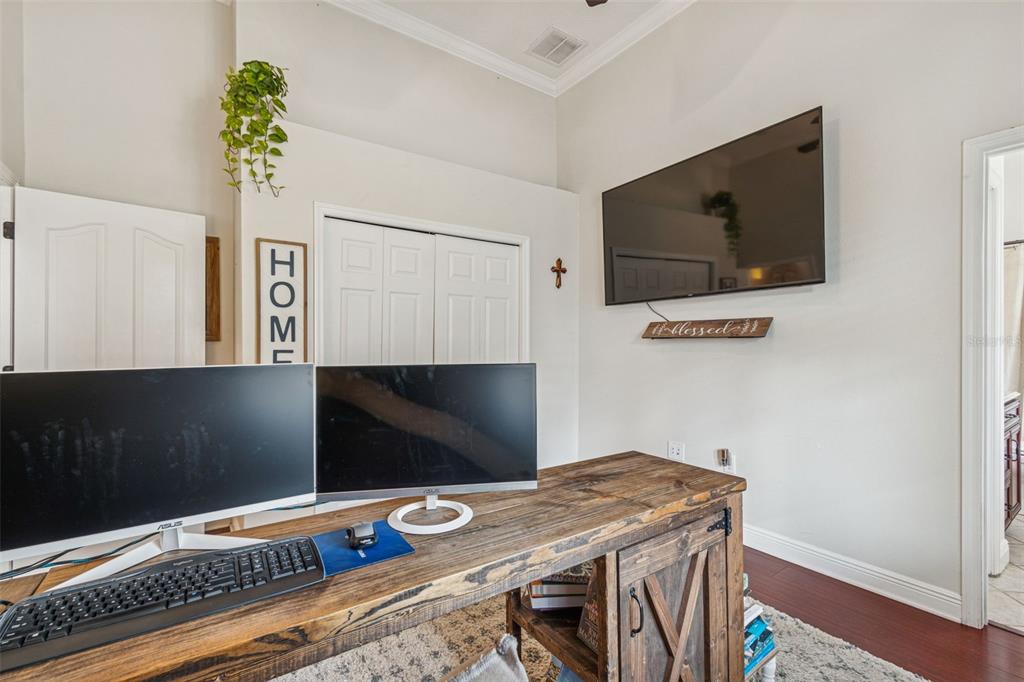 3077 Cork Road Plant City, FL 33565 - Photo 63 of 99 a bedroom with a bed and a flat screen tv