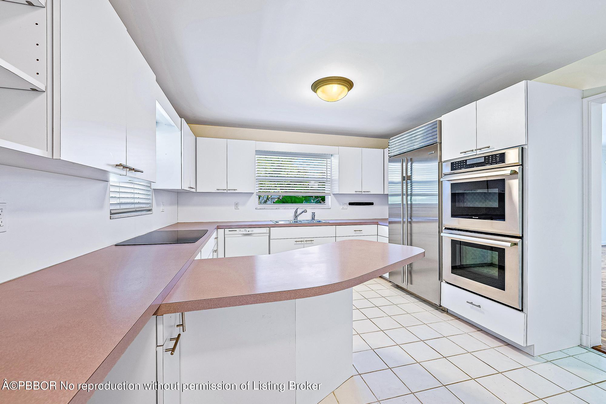 111 Reef Road Palm Beach, FL 33480 - Photo 10 of 28 a kitchen with stainless steel appliances granite countertop a sink a stove a microwave a counter top space and cabinets