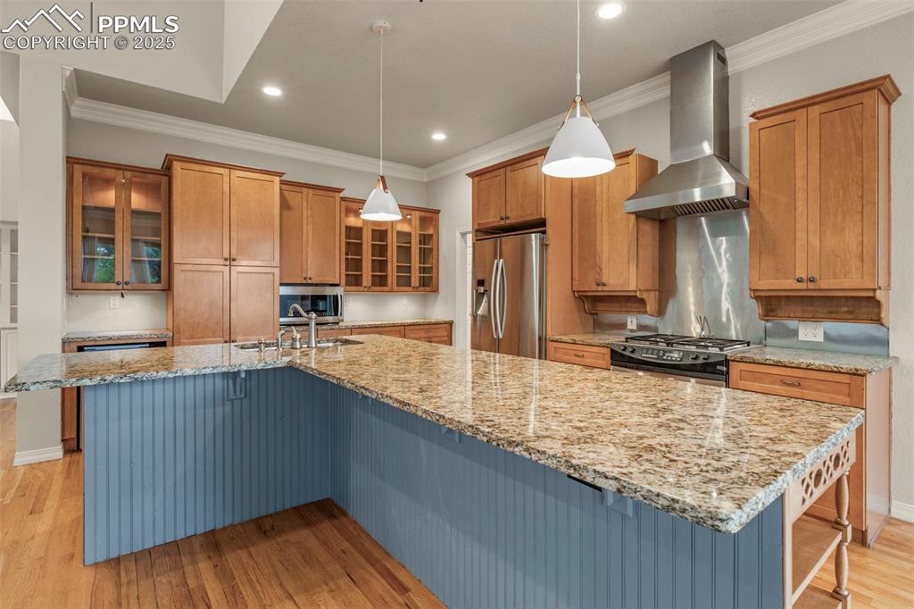 4930 Langdale Way Colorado Springs, CO 80906 - Photo 13 of 49 a kitchen with kitchen island granite countertop wooden cabinets a sink and dishwasher