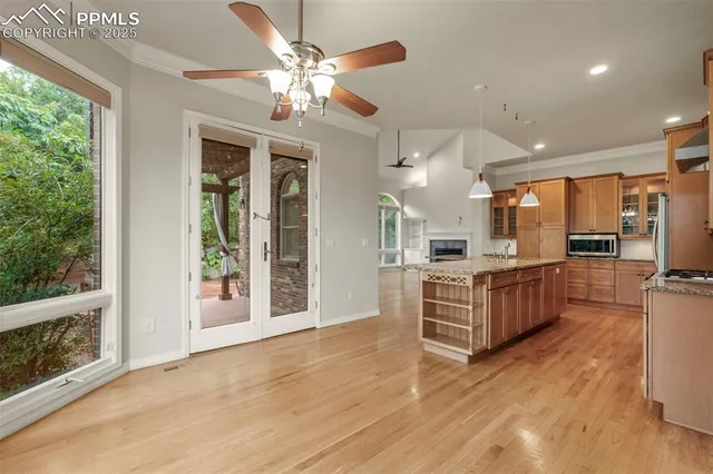 a large kitchen with stainless steel appliances granite countertop a large oven a stove oven and a refrigerator with wooden floor