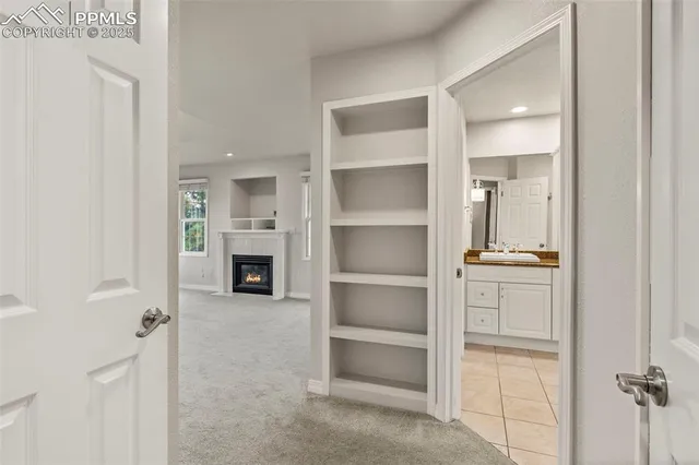 a view of a hallway with a livingroom and a kitchen space