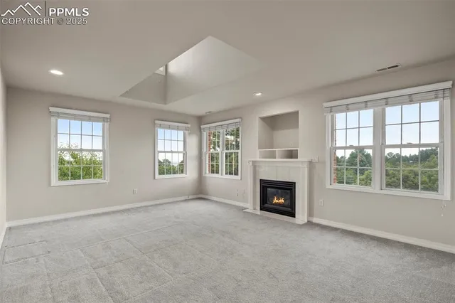 an empty room with furniture fireplace and windows