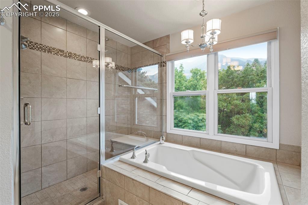 4930 Langdale Way Colorado Springs, CO 80906 - Photo 25 of 49 a bathroom with a window bathtub and chandelier
