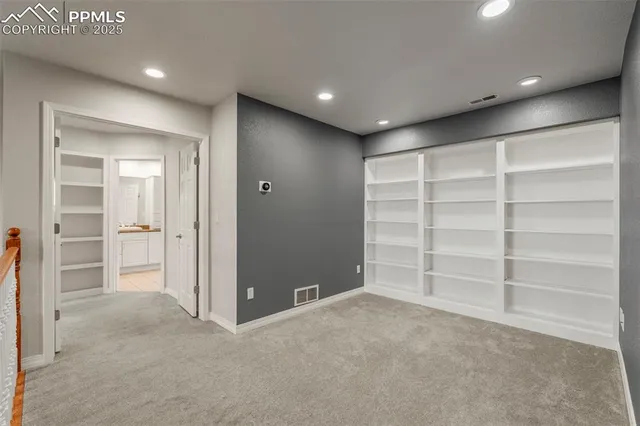a view of an empty room with a cabinet and a window