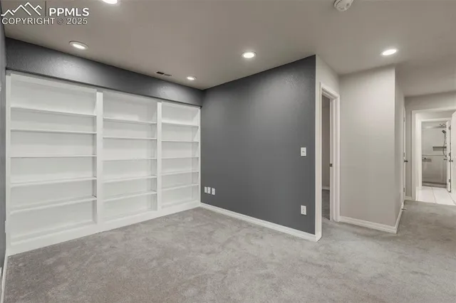 a view of an empty room with a cabinet and a window