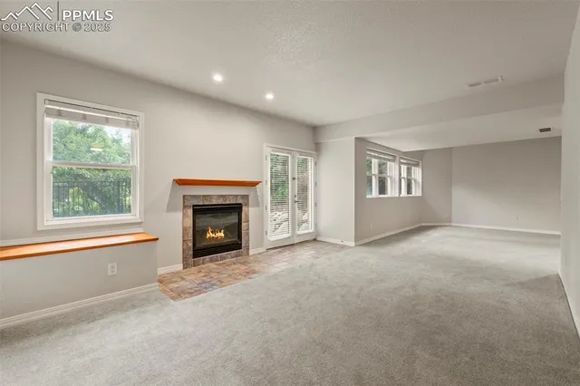 a view of an empty room with a window and fireplace