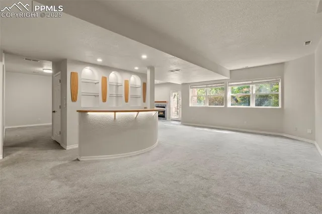 an empty room with a kitchen and a window