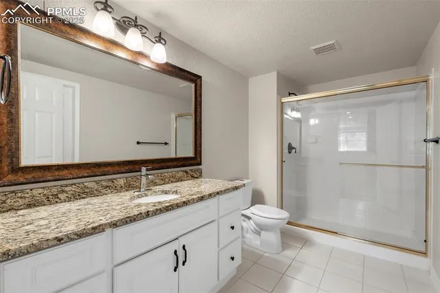 a bathroom with a granite countertop sink mirror and toilet