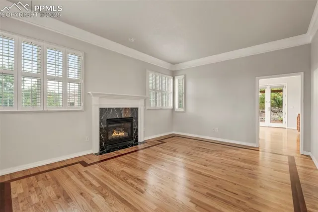 wooden floor fireplace and windows in an empty room