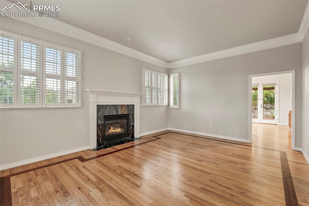 4930 Langdale Way Colorado Springs, CO 80906 - Photo 10 of 49 wooden floor fireplace and windows in an empty room