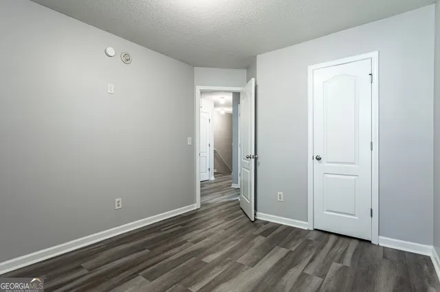 a view of an empty room with closet and a window