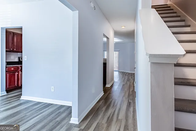 a view of a hallway with wooden floor and staircase