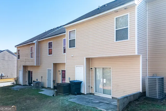 a front view of a house with a garden and chairs