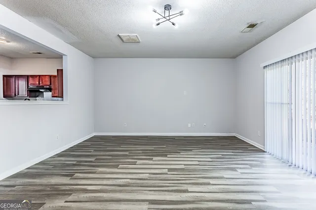 a view of a livingroom with wooden floor and a ceiling fan