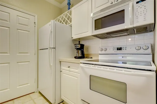 a kitchen with stainless steel appliances white cabinets and a refrigerator