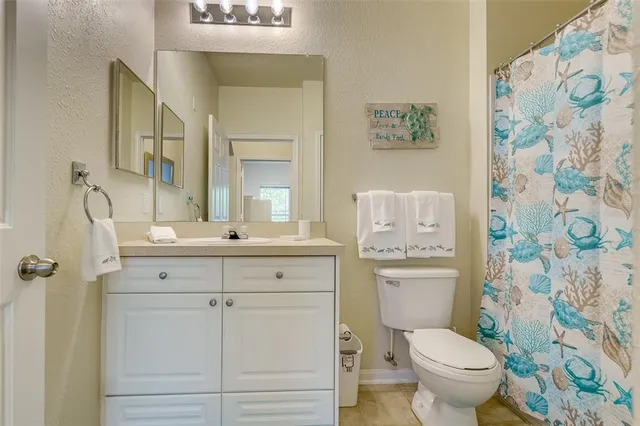 a bathroom with a granite countertop sink toilet and a mirror