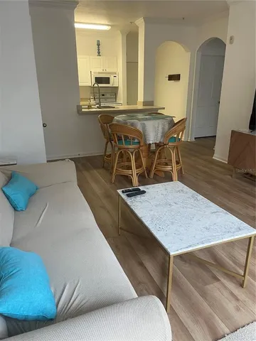a living room with a table chairs and wooden floor