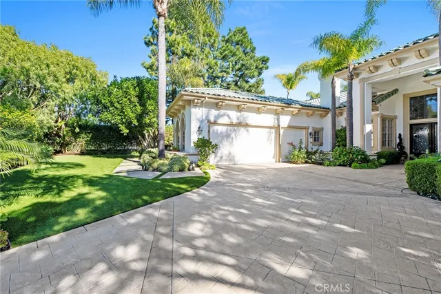 a front view of a house with a yard and potted plants