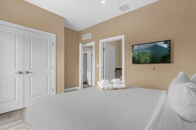 a bedroom with a bed and flat screen tv