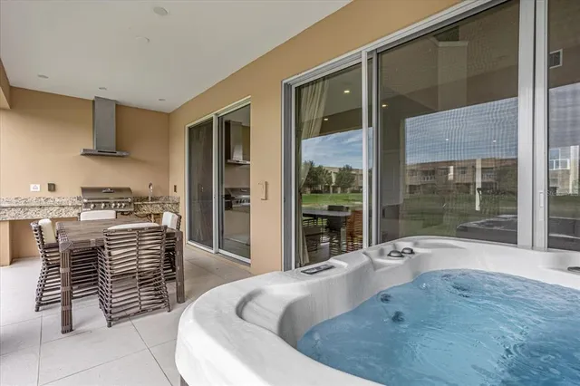 a large white kitchen with kitchen island a sink and a large window