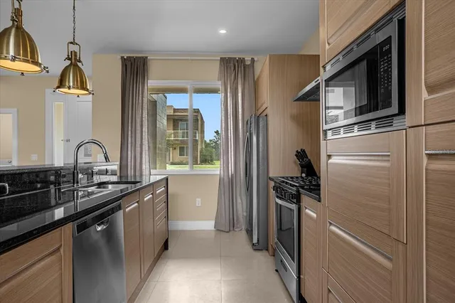 a kitchen with stainless steel appliances a sink stove and refrigerator