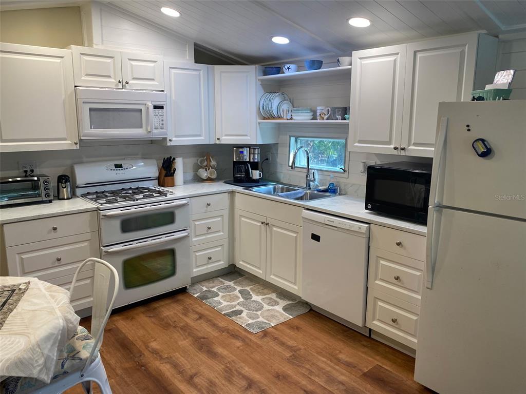 1300 State Rte 777, Unit W 86 Venice, FL 34293 - Photo 3 of 15 a kitchen with white cabinets and appliances