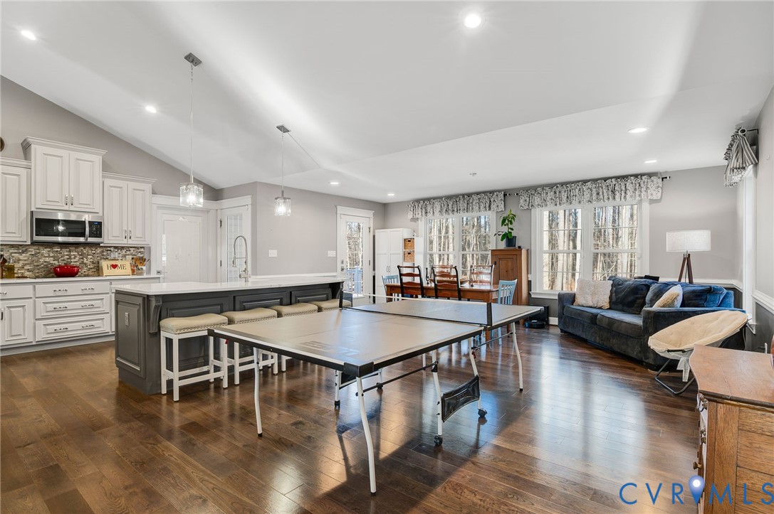 15330 Wilkinson Road Dinwiddie, VA 23841 - Photo 11 of 43 a kitchen with stainless steel appliances granite countertop a stove a refrigerator a kitchen island a dining table and chairs with wooden floor