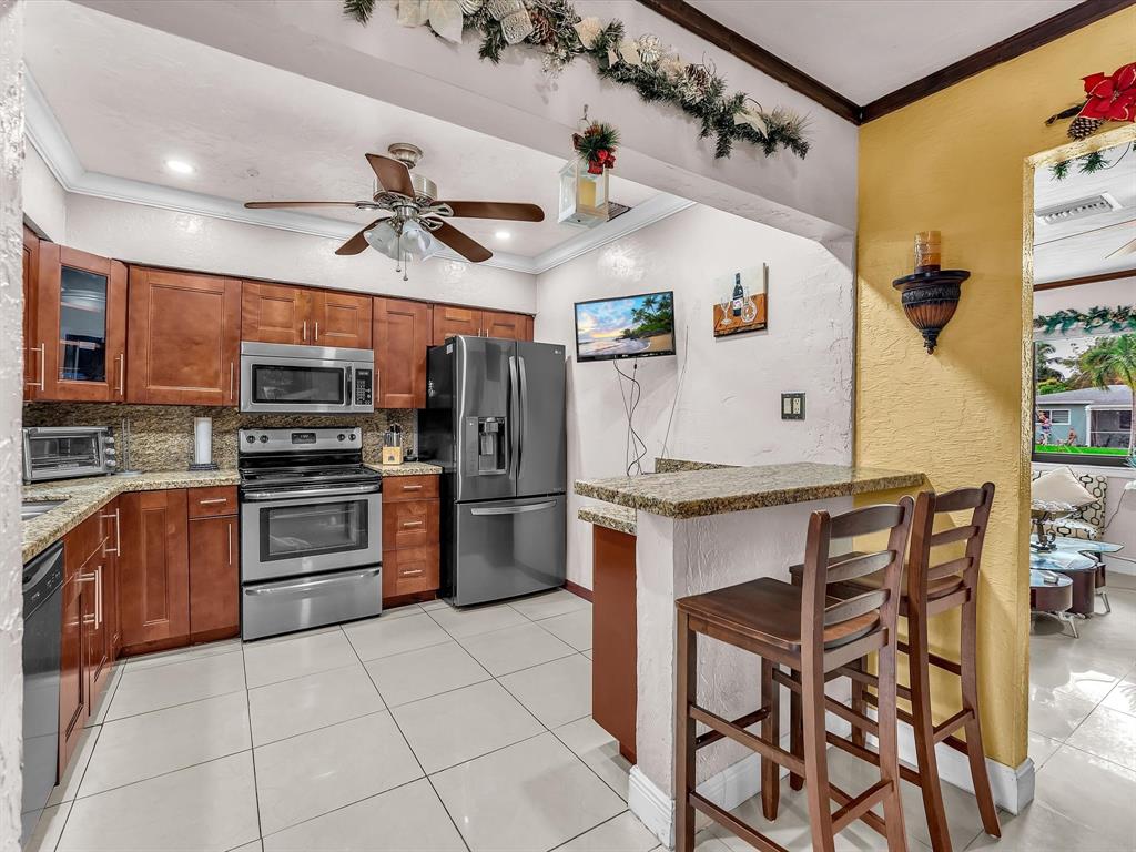 6631 Southwest 24th Street Miramar, FL 33023 - Photo 12 of 42 a kitchen with stainless steel appliances kitchen island granite countertop a sink and cabinets