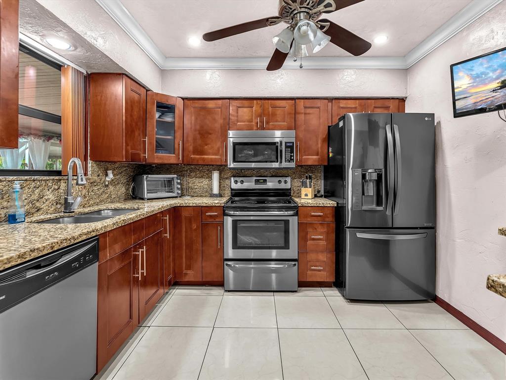6631 Southwest 24th Street Miramar, FL 33023 - Photo 13 of 42 a kitchen with stainless steel appliances granite countertop a refrigerator and a sink