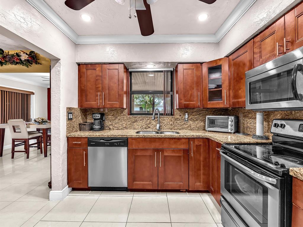 6631 Southwest 24th Street Miramar, FL 33023 - Photo 14 of 42 a kitchen with stainless steel appliances granite countertop a stove and a sink