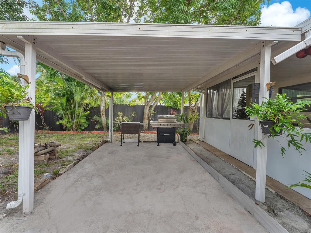6631 Southwest 24th Street Miramar, FL 33023 - Photo 29 of 42 a view of a patio with a table and chairs under an umbrella