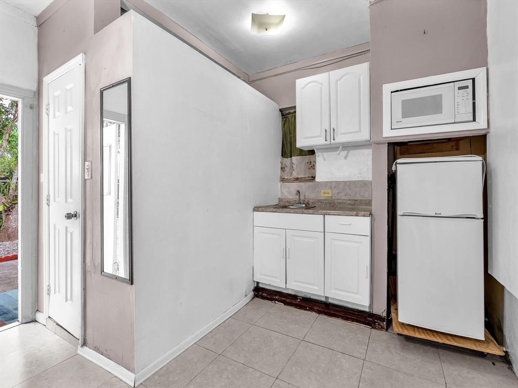 6631 Southwest 24th Street Miramar, FL 33023 - Photo 40 of 42 a kitchen with white cabinets and white appliances