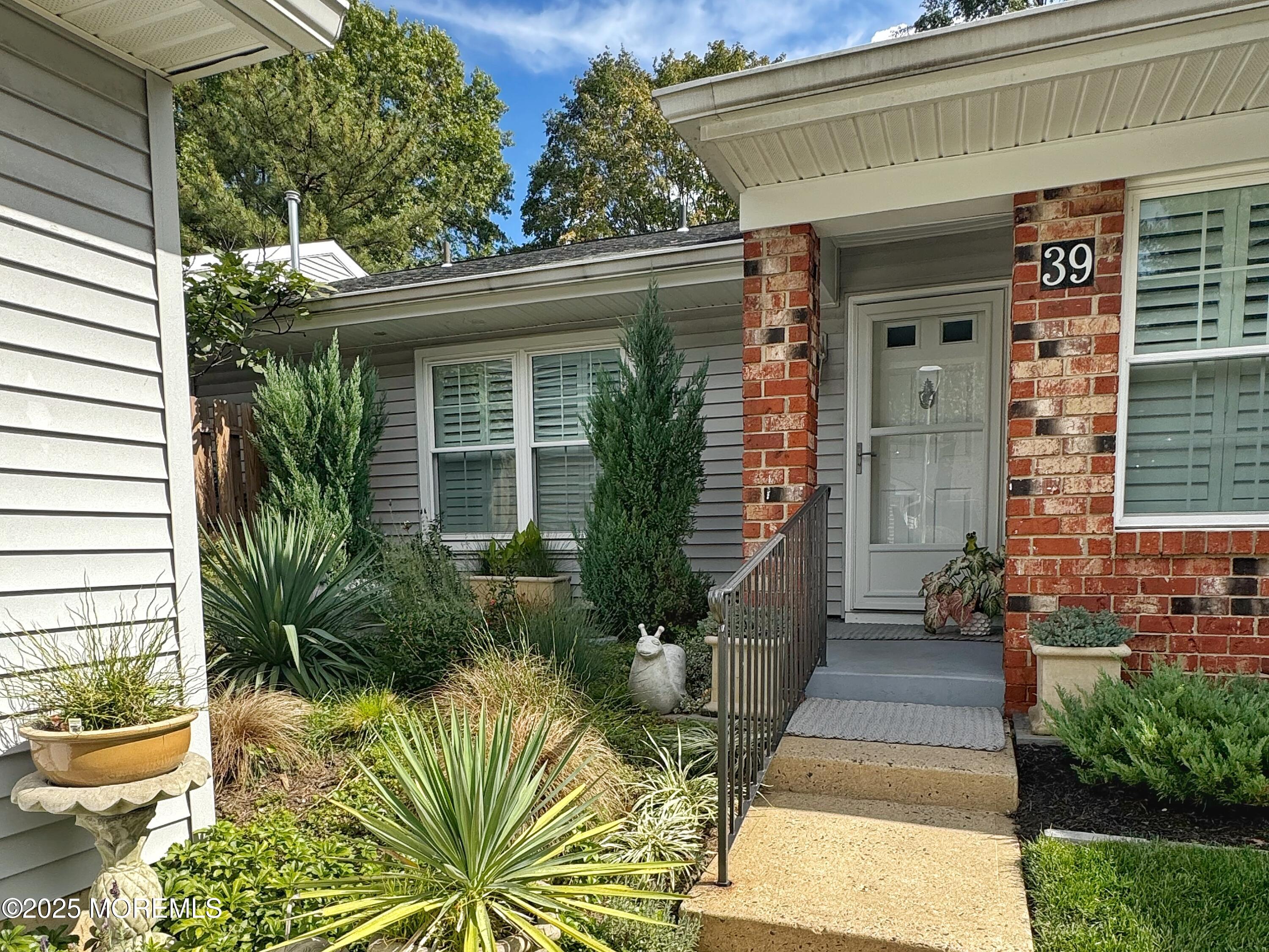 39 Boxwood Terrace Red Bank, NJ 07701 - Photo 3 of 25 a view of a house with potted plants and a bench in patio