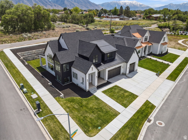 1682 North 1950 W Street, Unit 9 Provo, UT 84604 - Photo 6 of 84 Modern Farmhouse exterior featuring a multi-gable roofline with dark shingles, white siding, black window frames, and an expansive concrete driveway