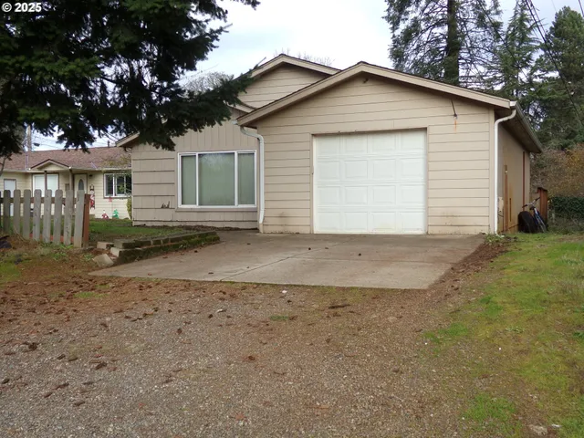 a view of a house with a yard and large tree