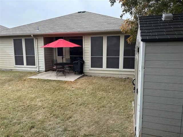 a backyard of a house with table and chairs