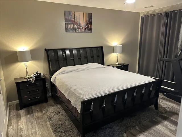 a large bed in a bedroom next to a lamp and a lamp