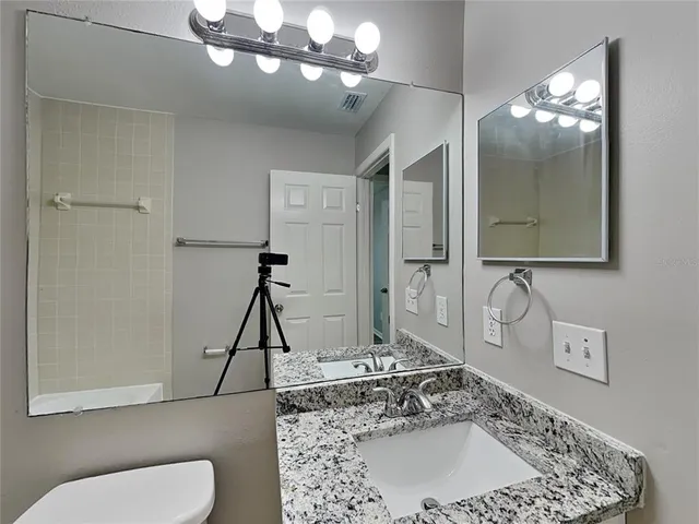 a bathroom with a sink a toilet and mirror