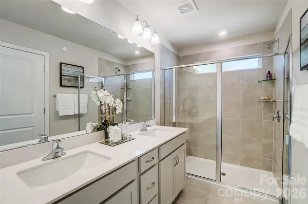 a bathroom with a shower sink and mirror