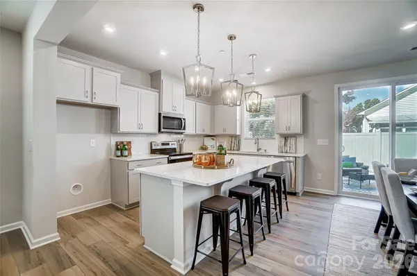 a kitchen with kitchen island granite countertop a sink a center island and appliances