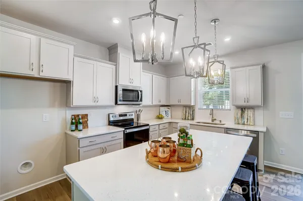 a kitchen with a sink a stove and chairs
