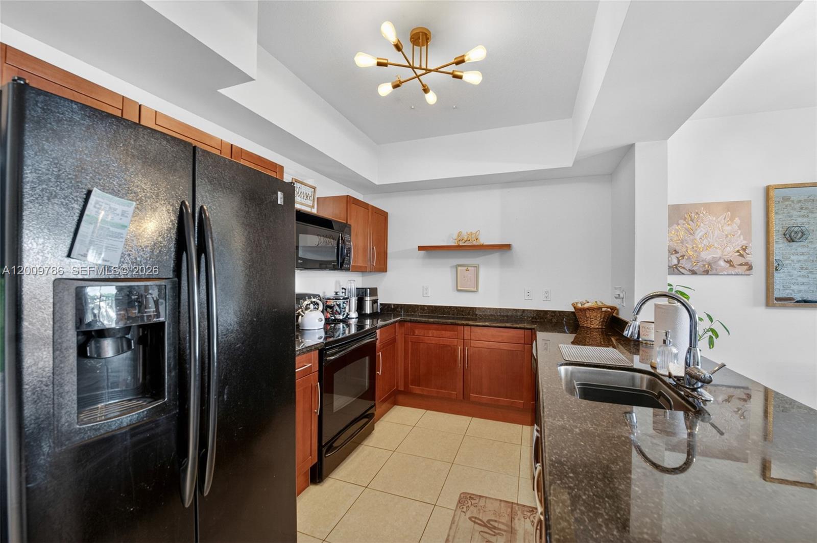 7266 Southwest 88th Street, Unit A403 Miami, FL 33156 - Photo 6 of 32 a kitchen with stainless steel appliances granite countertop a refrigerator and a sink