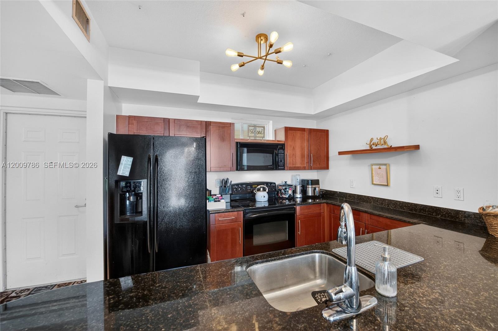 7266 Southwest 88th Street, Unit A403 Miami, FL 33156 - Photo 8 of 32 a kitchen with stainless steel appliances granite countertop a refrigerator a sink dishwasher a stove with a dining table and chairs